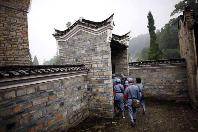 Mid-level government officials dressed in red army uniforms visit an old house where former Chinese leader Mao Zedong used to live during their 5-day training course at the communist party school called China Executive Leadership Academy of Jinggangshan, in Jiangxi province, in this September 21, 2012 file photo. China's Communist Party has dramatically stepped up its training of the country's roughly 40 million party and government officials in the past decade. With public scrutiny of cadre behaviour growing via social media, the party is likely to call for continued, and deepened, cadre education at the upcoming 18th Party Congress. At the vanguard of this education drive, alongside a Central Party School in Beijing, are three "Executive Leadership Academies" which opened in 2005 for middle-ranking and senior officials in Shanghai, Yan'an and Jinggangshan. The curriculum covers Marxism, Leninism and Mao Zedong Thought, but students may also take finance courses, receive in-depth media training or role-play crisis management scenarios on everything from disease outbreaks to train wrecks. REUTERS/Carlos Barria/Files (CHINA - Tags: POLITICS SOCIETY) Published: Zář. 24, 2012, 2:37 odp.