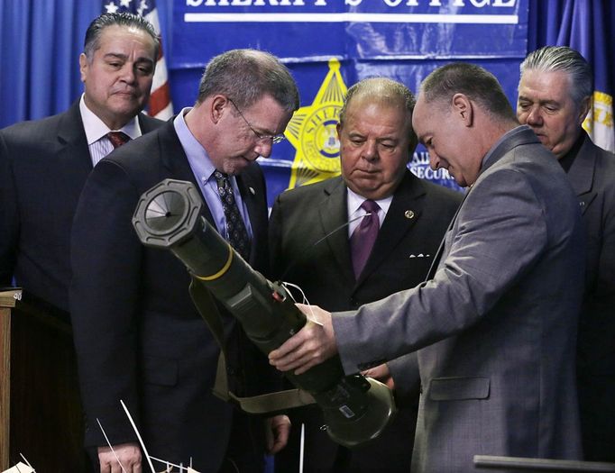 As Trenton Police Director Ralph Rivera, Jr., left, and Mercer County Sheriff John A. Kemler, back right, look on Tuesday, Jan. 29, 2013, in Trenton, N.J., Mercer County Prosecutor's Chief of Detectives Bill Straniero, second right, shows Mercer County Prosecutor Joseph Bocchini Jr., third right, and New Jersey Attorney General Jeffrey S. Chiesa, a military shoulder-fired rocket launcher that was turned in, as Chiesa prepared to announce that last weekend's gun buyback program in the state's capital brought in over 2,600 guns, including 700 that were illegal. (AP Photo/Mel Evans)