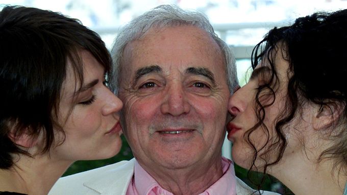 Charles Aznavour roku 2002 na festivalu v Cannes, líbaný zleva kanadskou herečkou Arsinée Khanjianovou, zprava Francouzkou Marie-Josée Crozeovou.