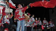 Maskot, vlajkonoš a bubeníci pardubického hokeje žhaví atmosféru krátce před příjezdem hokejistů. Autobus vezoucí zlatý náklad byl již v Chrudimi, napětí fanoušků vzrůstalo.