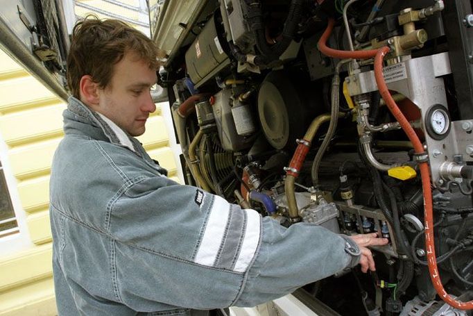 Technolog Karosy David Salášek ukazuje vstřikovací jednotku na plyn převzatou z osobních vozidel, zdvojenou pro potřebu motoru autobusu.