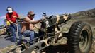 Ed Goloday works on his 75mm Pack Howitzer replica as another man recovers his shell casings during the Big Sandy Shoot in Mohave County, Arizona March 22, 2013. The Big Sandy Shoot is the largest organized machine gun shoot in the United States attended by shooters from around the country. Vintage and replica style machine guns and cannons are some of the weapons displayed during the event. Picture taken March 22, 2013. REUTERS/Joshua Lott (UNITED STATES - Tags: SOCIETY) Published: Bře. 25, 2013, 3:34 odp.