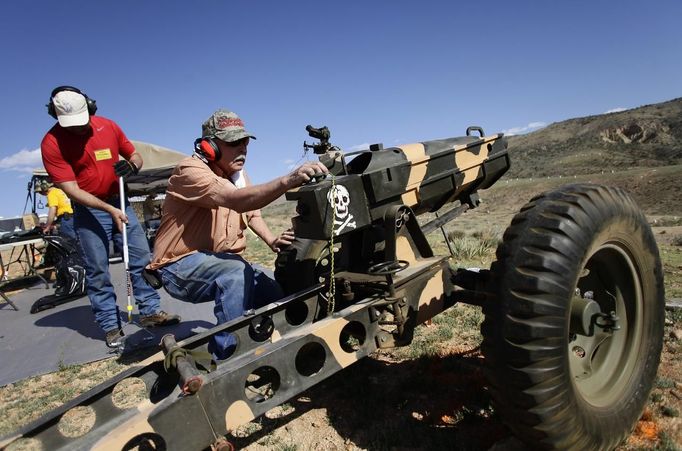 Ed Goloday works on his 75mm Pack Howitzer replica as another man recovers his shell casings during the Big Sandy Shoot in Mohave County, Arizona March 22, 2013. The Big Sandy Shoot is the largest organized machine gun shoot in the United States attended by shooters from around the country. Vintage and replica style machine guns and cannons are some of the weapons displayed during the event. Picture taken March 22, 2013. REUTERS/Joshua Lott (UNITED STATES - Tags: SOCIETY) Published: Bře. 25, 2013, 3:34 odp.