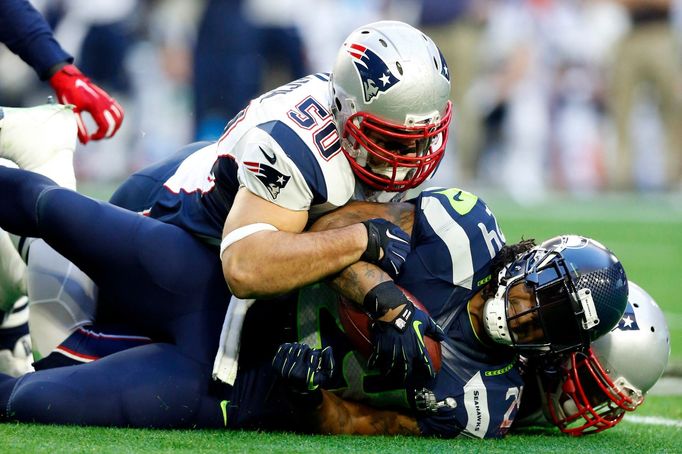 Feb 1, 2015; Glendale, AZ, USA; Seattle Seahawks running back Marshawn Lynch (24) is tackled by New England Patriots defensive end Rob Ninkovich (50) and outside lineback