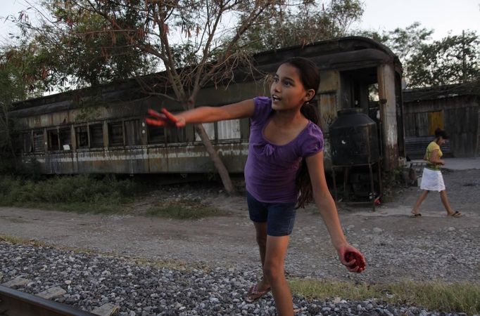 Ruth plays outside a train carriage she calls home in Cadereyta on the outskirts of Monterrey August 8, 2012. Ruth, her eight other family members and their pets have been living in the abandoned carriage next to a train track for the last 15 years. Ruth's grandparents moved from Tamaulipas to Cadereyta after one of their sons was killed on the street by a stray bullet. The family moved into the carriage which was empty after having been occupied by a vagabond, after living for the first five years in a rented room after arriving in Cadereyta. Picture taken August 8, 2012. REUTERS/Daniel Becerril (MEXICO - Tags: SOCIETY) Published: Srp. 11, 2012, 2:17 dop.