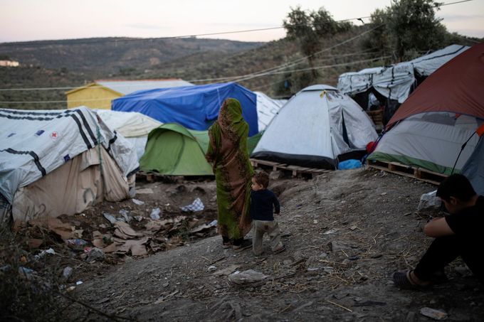 Žena s dítětem jdou do provizorní části uprchlického tábora Moria, ve které žijí lidé ve stanech.