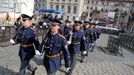 Střídání Hradní stráže mezi rozestavěnými tribunami na Hradčanském náměstí.