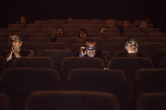 Students from the World Services for the Blind (WSB) sit to watch a movie inside a theater in Little Rock, Arkansas January 4, 2013. Robert Brown (L), visually impaired because of Stargardt disease, Dale Layne (C), blind with light perception because of glaucoma, and Cynda Bellamy, a sighted recreation specialist at the WSB, were preparing to watch "Cloud Atlas." The WSB is a rehabilitation center for the blind or visually impaired which offers life skills and career training programs designed to help those enrolled achieve sustainable independence. Picture taken on January 4, 2013. REUTERS/Gaia Squarci (UNITED STATES - Tags: EDUCATION HEALTH SOCIETY ENTERTAINMENT TPX IMAGES OF THE DAY) Published: Dub. 26, 2013, 2:13 odp.