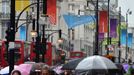 Shoppers hold umbrellas as they walk under London Olympic 2012 banners in Oxford Street in central London July 18, 2012. REUTERS/Toby Melville (BRITAIN - Tags: ENVIRONMENT SOCIETY SPORT OLYMPICS) Published: Čec. 18, 2012, 1:08 odp.