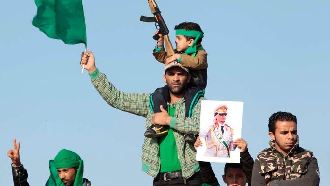 Pozůstalí se v Tripolisu účastní pohřbu těch, kteří zemřeli během náletů spojeneckcýh sil. Zelená barva značí loajalitu k vládě Muammara Kaddáfího.