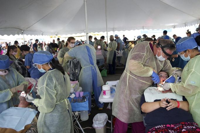 Dentists work on patients at the Remote Area Medical (RAM) clinic in Wise, Virginia July 20, 2012. RAM clinics bring free medical, dental and vision care to uninsured and under-insured people across the country and abroad. The Wise clinic was the 647th RAM expedition since 1985 and drew 1700 patients from 14 states, organizers said. Picture taken July 20, 2012. REUTERS/Mark Makela (UNITED STATES - Tags: HEALTH SOCIETY) Published: Čec. 24, 2012, 3:06 odp.