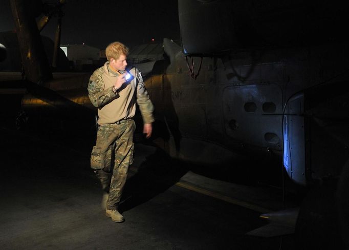 Britain's Prince Harry inspects his Apache helicopter before a night mission from Camp Bastion, southern Afghanistan in this photograph taken December 10, 2012, and released January 21, 2013. The Prince, who is serving as a pilot/gunner with 662 Squadron Army Air Corps, is on a posting to Afghanistan that runs from September 2012 to January 2013. Photograph taken December 10, 2012. REUTERS/John Stillwell/Pool (AFGHANISTAN - Tags: MILITARY POLITICS SOCIETY ROYALS CONFLICT) Published: Led. 21, 2013, 8:14 odp.