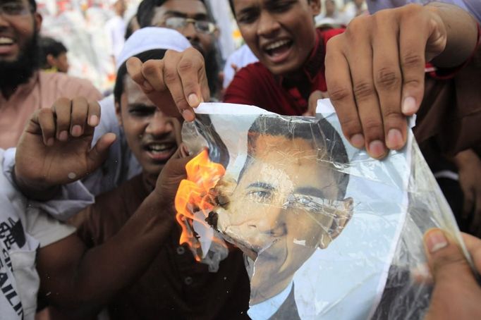 Bangladeshi Muslims burn a picture of U.S. President Barack Obama during a protest in front of the National Press Club in Dhaka September 21, 2012. About 10,000 Bangladeshi Muslims participated in demonstrations after Friday prayers in Bangladesh's capital against an anti-Islam film made in the U.S. and also against cartoons mocking the Prophet Mohammad published on Wednesday in a French magazine. REUTERS/Andrew Biraj (BANGLADESH - Tags: RELIGION POLITICS CIVIL UNREST) Published: Zář. 21, 2012, 10:45 dop.