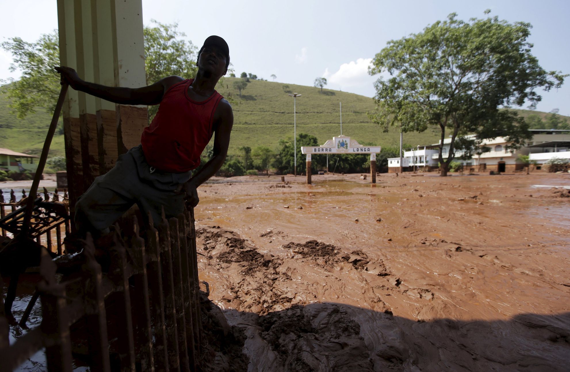 Muž si prohlíží spoušť, kterou zanechalo bahno v jedné z postižených brazilských vesnic.