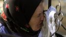 Belarussian woman kisses portrait at her relative's grave during "Radunitsa" in abandoned village of Lomysh