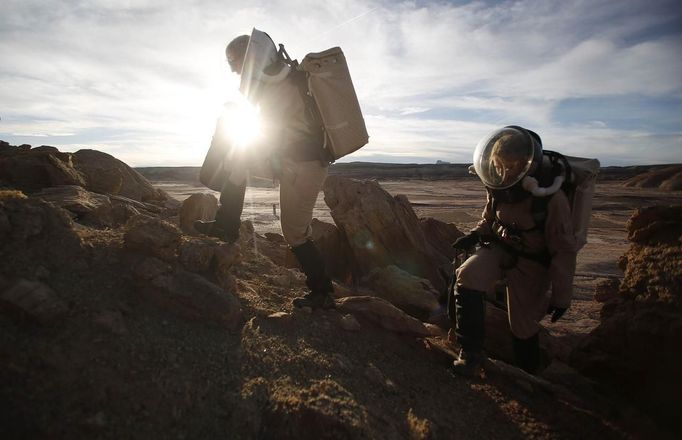 Melissa Battler (L), a geologist and commander of the Crew 125 EuroMoonMars B mission, and Csilla Orgel, a geologist, climb a rock formation to collect geologic samples for study at the Mars Desert Research Station (MDRS) in the Utah desert March 2, 2013. The MDRS aims to investigate the feasibility of a human exploration of Mars and uses the Utah desert's Mars-like terrain to simulate working conditions on the red planet. Scientists, students and enthusiasts work together developing field tactics and studying the terrain. All outdoor exploration is done wearing simulated spacesuits and carrying air supply packs and crews live together in a small communication base with limited amounts of electricity, food, oxygen and water. Everything needed to survive must be produced, fixed and replaced on site. Picture taken March 2, 2013. REUTERS/Jim Urquhart (UNITED STATES - Tags: SCIENCE TECHNOLOGY SOCIETY ENVIRONMENT) ATTENTION EDITORS: PICTURE 18 OF 31 FOR PACKAGE 'MARS IN THE DESERT' SEARCH 'JIM MARS' FOR ALL IMAGES Published: Bře. 11, 2013, 2:05 odp.