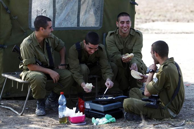 REFILE - CORRECTING LOCATION WHERE PICTURE WAS TAKEN Israeli soldiers from an Iron Dome unit eat at their base in the southern city of Ashdod November 15, 2012. A Hamas rocket killed three Israelis north of the Gaza Strip on Thursday, drawing the first blood from Israel as the Palestinian death toll rose to 15 in a military showdown lurching closer to all-out war and an invasion of the enclave. REUTERS/Amir Cohen (ISRAEL - Tags: POLITICS CIVIL UNREST MILITARY) Published: Lis. 15, 2012, 7:18 odp.