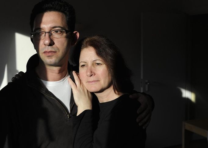 George Kapetanios poses for a photograph with his wife Katarina Germanou at their flat in Potters Bar, on the outskirts of London