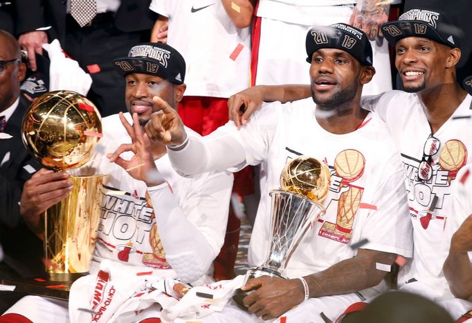 Miami Heat's Dwyane Wade (L), LeBron James (C) and Chris Bosh celebrate winning the NBA Championship following Game 7 of their NBA Finals basketball playoff against the S