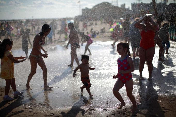 People play in the water at Coney Island in the Brooklyn section of New York June 23, 2012. REUTERS/Eric Thayer (UNITED STATES - Tags: ENVIRONMENT SOCIETY) Published: Čer. 24, 2012, 12:09 dop.