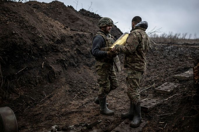 Ukrainian servicemen hold a howitzer shell at a position near the front line town of Bakhmut, amid Russia's attack on Ukraine, in Donetsk region, Ukraine December 21, 202