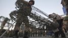 A soldier carries barbed wire fencing near army soldiers taking positions in front of protesters who are against Egyptian President Mohamed Mursi, near the Republican Guard headquarters in Cairo July 3, 2013. Egypt's armed forces overthrew elected Islamist President Mohamed Mursi on Wednesday and announced a political transition with the support of a wide range of political, religious and youth leaders. A statement published in Mursi's name on his official Facebook page after head of Egypt's armed forces General Abdel Fattah al-Sisi's speech said the measures announced amounted to "a full military coup" and were "totally rejected". REUTERS/Amr Abdallah Dalsh (EGYPT - Tags: POLITICS CIVIL UNREST MILITARY) Published: Čec. 3, 2013, 8:18 odp.