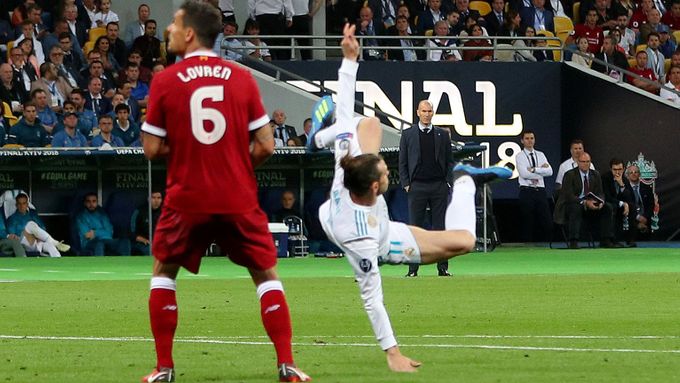 ŠMIK, ŠMIK. Gareth Bale dokončuje akrobatický kousek a Dejan Lovren sleduje míč letící do brány.