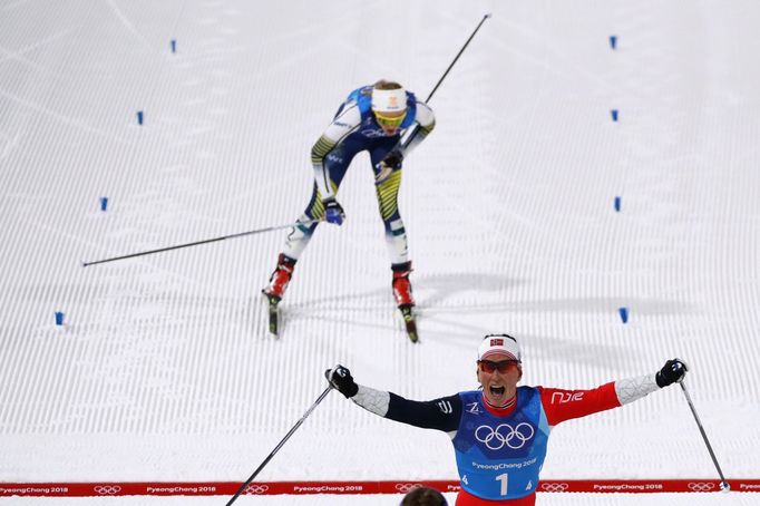 Marit Björgenová slaví vítězství Norska ve štafetě 4x5 km na ZOH 2018. Za ní  Stina Nilssonová ze Švédska.