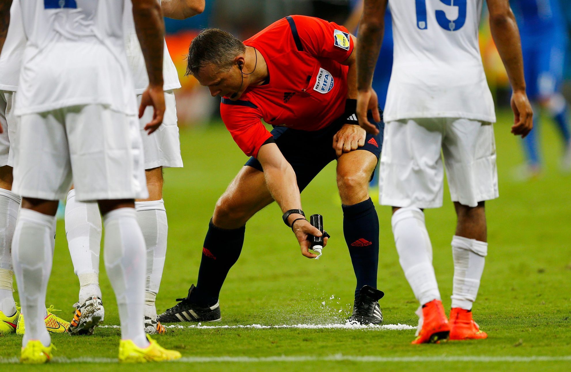 Referee Bjorn Kuipers of the Netherlands marks out a line with an invisible spray during the 2014 World Cup Group D soccer match between England and Italy at the Amazonia arena in Manaus