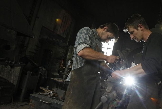 Blacksmith brothers Johann (R) and Georg Schmidberger work on a harness for the Vatican Swiss Guard at their workshop in Molln, Upper Austria June 12, 2012. Johann, 29, and Georg, 28, produce made-to-order handmade harnesses for the Vatican, which take 120 hours of handiwork per piece and hardly differs from the 500-year-old originals. The brothers carry on the tradition of the blacksmith trade in the fifth generation of their family. REUTERS/Lisi Niesner (AUSTRIA - Tags: SOCIETY MILITARY) Published: Čer. 12, 2012, 10:14 odp.