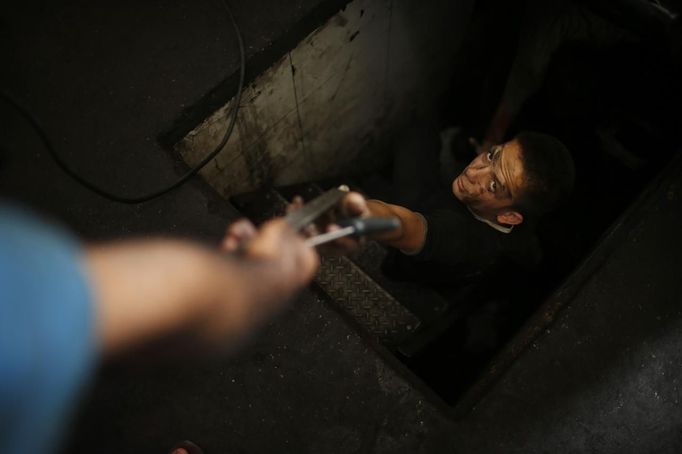 Palestinian Ali al-Batniji (R), 18, works in a car repair garage in Gaza City May 30, 2013. Al-Batniji left school to work as an apprentice in the garage so that he could support his family's income. Apprentice mechanics earn around $100 per month, garage owners said. REUTERS/Mohammed Salem (GAZA - Tags: TRANSPORT SOCIETY BUSINESS EMPLOYMENT) Published: Kvě. 30, 2013, 12:54 odp.