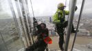 The City of London is seen behind as workers climb up the exterior of the Shard as seen from the viewing platform which opened to the public today, in London