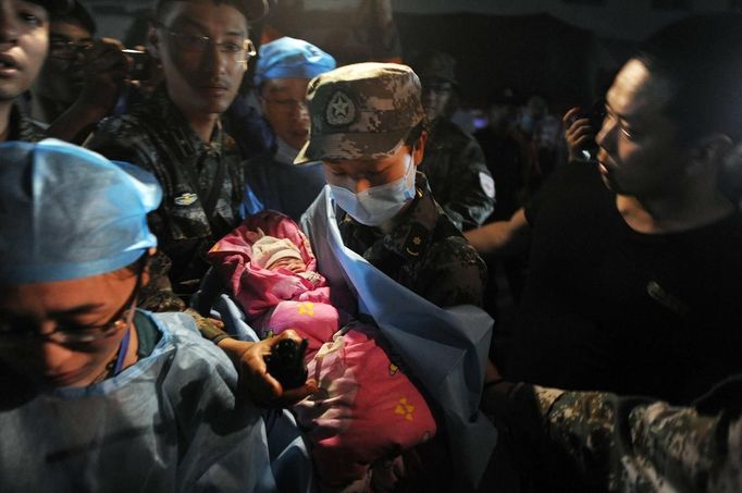 A new-born baby which was born in a relief tent is attended by medical staff after Saturday's earthquake hit Lushan county, Ya'an, Sichuan province, April 22, 2013. Hundreds of survivors of an earthquake that killed nearly 200 people in southwest China pushed into traffic on a main road on Monday, waving protest signs, demanding help and shouting at police. The Chinese characters on the tent read "Disaster relief". Picture taken April 22, 2013. REUTERS/Stringer (CHINA - Tags: DISASTER SOCIETY TPX IMAGES OF THE DAY) Published: Dub. 23, 2013, 3:46 dop.