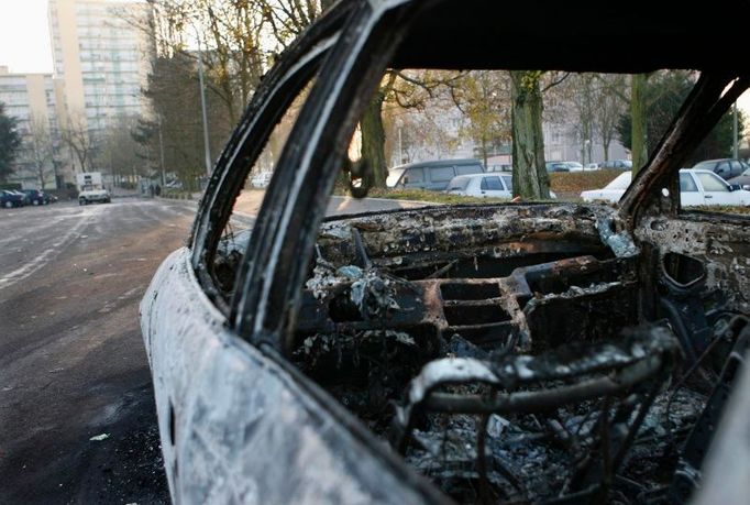 Přes noc se zde bojovalo, ráno už je tu klid. Ohořelé auto ve Villiers-le-Bel.