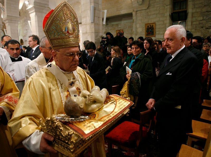 Latinský patriarcha Michael Sabbah nese sošku malého Ježíška při půlnoční mši v Betlémě.