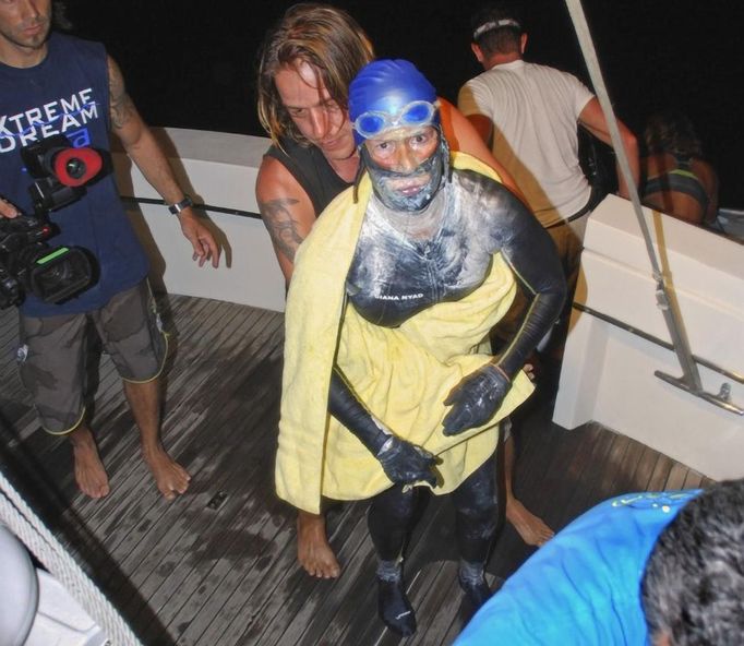 Veteran long-distance swimmer Diana Nyad is aided after she was pulled out of the water between Cuba and the Florida Keys early August 21, 2012. The 62-year-old American, who battled squalls, rough seas and jellyfish, had set out from Cuba on Saturday had spend more than 60 hours in the water before she abandoned the swim. REUTERS/Christi Barli/The Florida keys News Bureau/Handout (UNITED STATES) Published: Srp. 21, 2012, 2:15 odp.