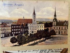 Vidnava na historické pohlednici s kostelem a radnicí.
