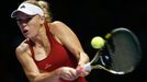 Caroline Wozniacki of Denmark hits a return to Serena Williams of the U.S. during their WTA Finals singles semi-finals tennis match at the Singapore Indoor Stadium Octobe