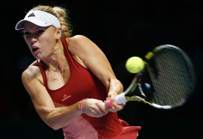 Caroline Wozniacki of Denmark hits a return to Serena Williams of the U.S. during their WTA Finals singles semi-finals tennis match at the Singapore Indoor Stadium Octobe