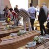 People put flowers on the coffins of 13 unidentified migrants who died in the April 19, 2015 shipwreck, during an inter-faith funeral service in Catania