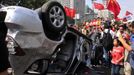 Demonstrators hold Chinese flags and banners beside an overturned car of a Japanese brand during a protest in Xi'an, Shaanxi province September 15, 2012. Thousands of Chinese besieged the Japanese embassy in Beijing on Saturday, hurling rocks, eggs and bottles with protests reported in other major cities in China amid growing tension between Asia's two biggest economies over a group of disputed islands. REUTERS/Rooney Chen (CHINA - Tags: POLITICS) CHINA OUT. NO COMMERCIAL OR EDITORIAL SALES IN CHINA