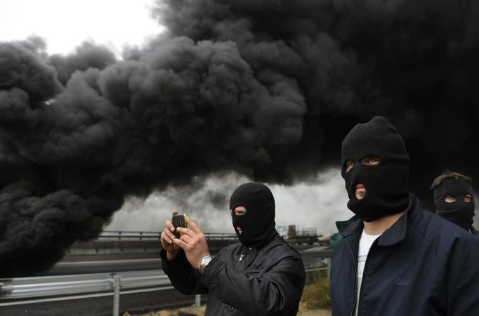 Miners on strike take pictures near barricades of burning tyres on the A-6 motorway, on the second day of a strike to protest the government's spending cuts in the mining sector, in El Montico, near Oviedo, northern Spain, May 24, 2012. Spain's economy is contracting for the second time since late 2009 and four years of stagnation and recession have pushed unemployment above 24 percent, the highest rate in the European Union. REUTERS/Eloy Alonso (CIVIL UNREST BUSINESS EMPLOYMENT ENERGY TPX IMAGES OF THE DAY) Published: Kvě. 24, 2012, 10:03 dop.