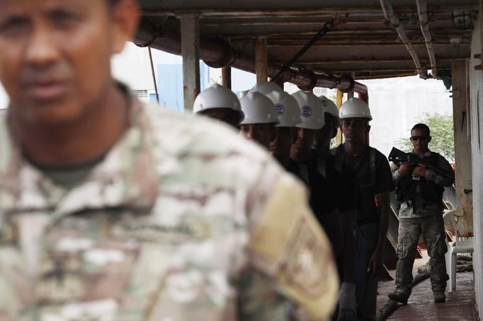 Police officers stand guards onboard a North Korean flagged ship "Chong Chon Gang" docked at the Manzanillo Container Terminal in Colon City July 16, 2013. Panama detained the North Korean-flagged ship from Cuba as it headed to the Panama Canal and said it was hiding weapons in brown sugar containers, sparking a standoff in which the ship's captain attempted to commit suicide. Panama's President Ricardo Martinelli said the undeclared weapons were detected inside the containers when Panamanian authorities stopped the ship, suspecting it was carrying drugs. REUTERS/Carlos Jasso (PANAMA - Tags: CRIME LAW DRUGS SOCIETY POLITICS) Published: Čec. 16, 2013, 9:59 odp.