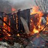 Dům, který začal hořet po nedávném ostřelování v separatisty kontrolovaném městě Doněck na Ukrajině.
