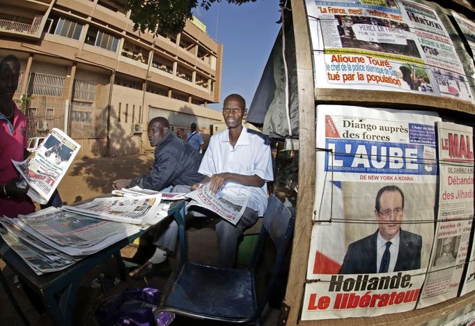 A man reads a newspaper at a street vendor's stand in Bamako January 21, 2013. The front page of a newspaper shows French President Francois Hollande and reads "Hollande, the Liberator". French troops in armoured vehicles advanced on Sunday towards a central Malian town abandoned by Islamist rebels after days of air strikes, moving cautiously for fear of guerrilla-style counterattacks by the al Qaeda-linked fighters. REUTERS/Eric Gaillard (MALI - Tags: CIVIL UNREST CONFLICT) MILITARY) Published: Led. 21, 2013, 11:29 dop.