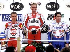 Druhý Kevin Schwantz, vítězný Wayne Rainey a třetí Mick Doohan na stupních vítězů závodu třídy do 500 ccm v Misanu 1990.