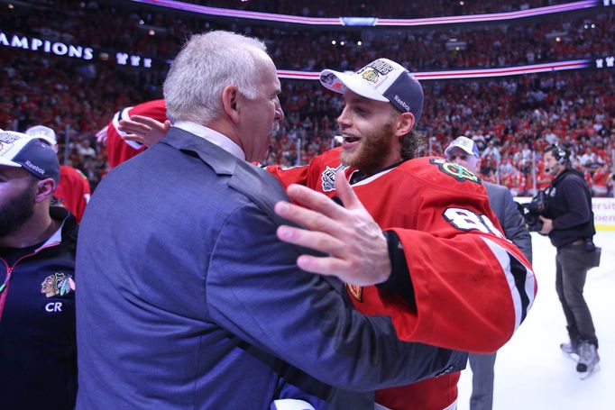 Patrick Kane slaví zisk Stanley Cupu s trenérem Chicaga  Joelem Quennevillem.