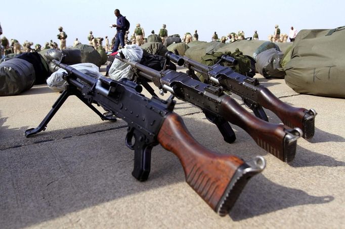 Guns are arranged on the ground as Nigerian soldiers prepare to board a military plane before leaving for Mali, at the airport in Nigeria's northern state of Kaduna January 17, 2013. The first West African regional forces arrived in Mali on Thursday to reinforce French and Malian troops battling to push back al Qaeda-linked rebels after seven days of French air strikes. A contingent of around 100 Togolese troops landed in Bamako and was due to be joined by Nigerian forces already en route. Picture taken January 17, 2013. REUTERS/Afolabi Sotunde (NIGERIA - Tags: MILITARY POLITICS CIVIL UNREST) Published: Led. 18, 2013, 4:46 dop.