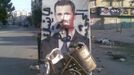 A defaced poster of Syria's President Bashar al-Assad is seen near garbage containers in Aleppo July 24, 2012. The words on the poster read, "We coming, duck ass". Picture taken July 24, 2012. REUTERS/Shaam News Network/Handout (SYRIA - Tags: POLITICS CIVIL UNREST) FOR EDITORIAL USE ONLY. NOT FOR SALE FOR MARKETING OR ADVERTISING CAMPAIGNS. THIS IMAGE HAS BEEN SUPPLIED BY A THIRD PARTY. IT IS DISTRIBUTED, EXACTLY AS RECEIVED BY REUTERS, AS A SERVICE TO CLIENTS Published: Čec. 25, 2012, 9:41 dop.