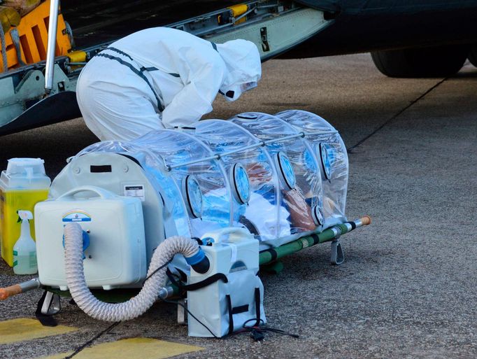 Španělský zdravotník kontroluje pacienta nakaženého ebolou, katolického kněze Manuela Garcia Viejo, před transportem do Španělska, kde má probíhat léčba.